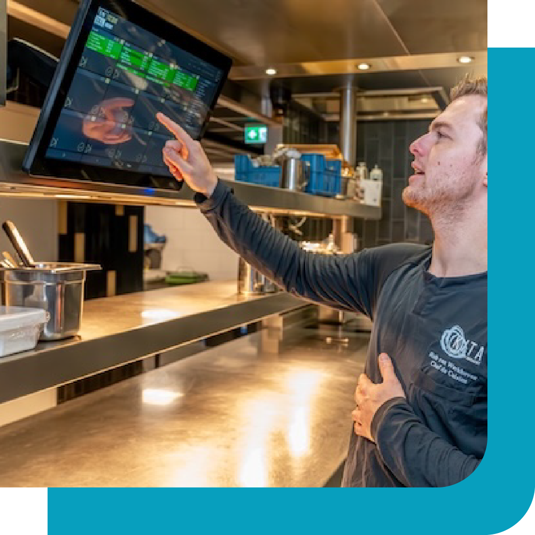 keukenbrigade werkt met een untill keukenscherm in een restaurant
